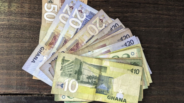 Ghana cedi banknotes sit arranged on a table in Accra, Ghana, on Thursday, March 15, 2018. Ghana wants to shake up the way it collects tax with the International Monetary Fund telling the government that it’s not raising sufficient income.