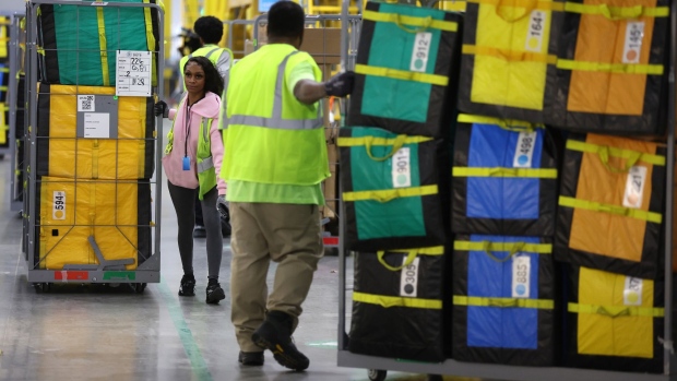 ALPHARETTA, GEORGIA - NOVEMBER 28: Amazon workers move carts filled with packages at an Amazon delivery station on November 28, 2022 in Alpharetta, Georgia. Amazon is offering deep discounts on popular products for Cyber Monday, its busiest shopping day of the year. (Photo by Justin Sullivan/Getty Images)