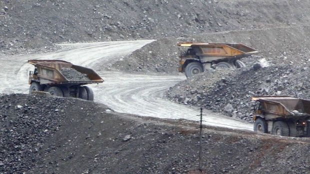 Haul trucks transport ore from the open pit at Freeport McMoRan Inc.'s Grasberg copper and gold mining complex in Papua province, Indonesia, on Wednesday, April 22, 2015. Freeport is the world's largest publicly traded copper producer. Photographer: Dadang Tri