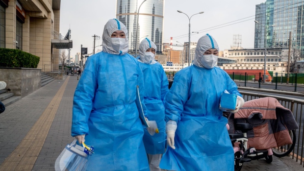 Workers in protective gear in Beijing, China, on Monday, Nov. 28, 2022. Covid-19 cases in China's capital remain elevated, after almost doubling at the weekend, as opposition to the government’s hardcore containment regime explodes onto the streets.