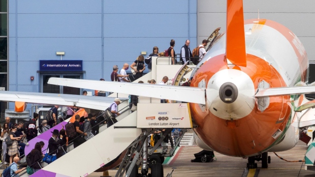 Passengers board an aircraft, operated by EasyJet Plc, at London Luton Airport in Luton, U.K., on Monday, July 25, 2022. EasyJet are due to report their latest earnings on Tuesday. Photographer: Chris Ratcliffe/Bloomberg