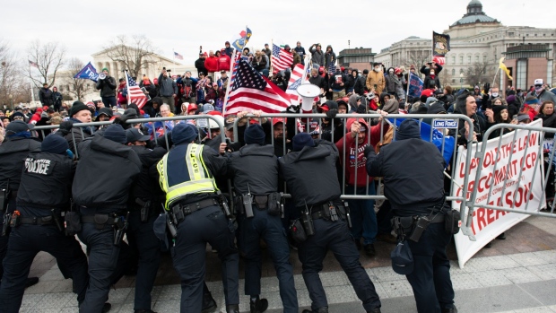 U.S. Capitol Police scuffle with demonstrators after they broke through security fencing outside of the U.S. Capitol building in Washington, D.C., U.S., on Wednesday, Jan. 6, 2021. The House and Senate will meet in a joint session today to count the Electoral College votes to confirm President-elect Joe Biden's victory, but not before a sizable group of Republican lawmakers object to the counting of several states' electors.