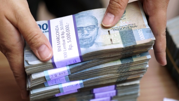 An employee handles Indonesian 50,000 rupiah banknotes at a PT Ayu Masagung currency exchange in Jakarta, Indonesia, on Tuesday, Aug. 18, 2020. Rupiah, Asia’s worst-performing currency this quarter, is due for a turnaround and it may begin this week should Bank Indonesia leave interest rates on hold. Photographer: Dimas Ardian/Bloomberg