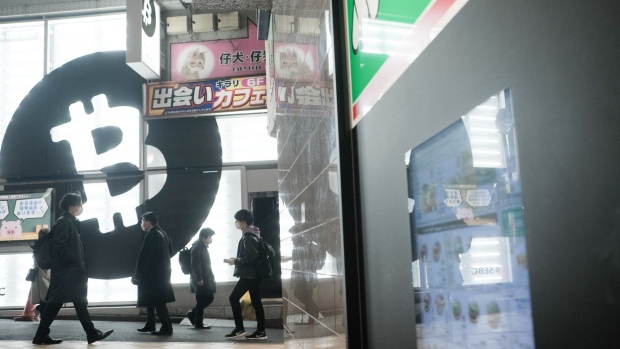 Pedestrians walk past a Sakura Bitcoin Exchange Inc. store in the Shibuya district of Tokyo on Friday, Feb. 25, 2022. Cryptocurrency exchanges are still trying to figure out how to deal with western sanctions against Russia after its invasion of Ukraine. Photographer: Soichiro Koriyama/Bloomberg