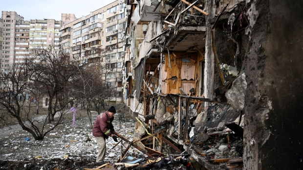 A man clears debris at a damaged residential building in Kyiv, in February 2022. Photographer: Daniel Leal/AFP/Getty Images