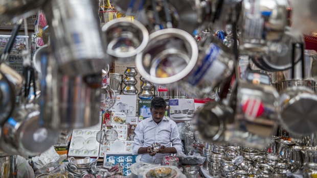 A vendor packs a stainless steel utensil at a marketplace ahead of the festival of Diwali in Noida, on the outskirts of New Delhi, on Saturday, Oct. 22, 2022. Indian shoppers are back in force online and in stores, splurging this festive season after the coronavirus pandemic damped celebrations and consumption in previous years.