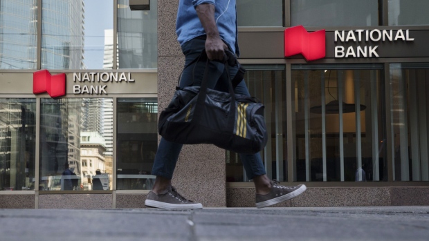 A pedestrian walks past a National Bank of Canada branch in the financial district of Toronto, Ontario, Canada, on Wednesday, July 11, 2018. Canadian stocks were mixed Friday as health care tumbled and energy rose, even as was still on pace for a weekly loss amid escalating trade war risks. Photographer: Brent Lewin/Bloomberg