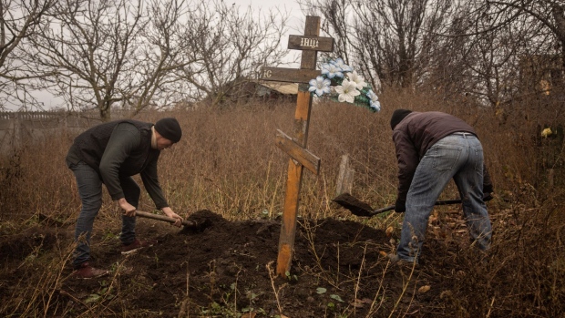 KHERSON, UKRAINE - NOVEMBER 28: Local residents help police, forensic experts and war crimes prosecution teams to exhume a burial site containing the bodies of six civilians that were executed by Russian forces in the yard of a house in the town of Pravdyne on the outskirts of Kherson on November 28, 2022 in Kherson, Ukraine. Eight people were killed at the house when an informant told Russian forces the civilians were passing on information to Ukrainian military sources. The bodies were found with their hands tied, blindfolded and shot at close range in the back of the head. Afterwards the house was blown up and the bodies were later buried in a grave next to the house by local residents. (Photo by Chris McGrath/Getty Images)