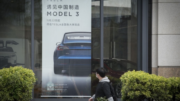 An advertisement for the Tesla Model 3 is displayed at a Tesla Inc. dealership in Shanghai, China on Monday, April 6, 2020. China, the biggest market for electric cars, is considering a reduction in rebates given to buyers and limits on the models that qualify even as it commits to extending the costly subsidy program for another two years. Photographer: Qilai Shen/Bloomberg