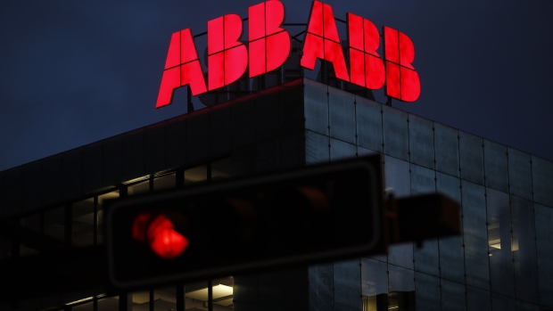 An illuminated logo stands on the roof of an ABB Ltd. plant at night in Baden, Switzerland, on Monday, Dec. 17, 2018. Hitachi Ltd.'s planned takeover of ABB's power grid division for about $6.4 billion will be the Japanese conglomerate's biggest-ever deal as it shifts focus from nuclear plants to the higher-growth market for electricity networks.