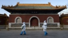 BEIJING, CHINA - DECEMBER 03: Epidemic control workers wear PPE as they walk by the Huangsi Temple on their way to perform nucleic acid tests on people under lockdown or health monitoring for COVID-19 on December 3, 2022 in Beijing, China. (Photo by Kevin Frayer/Getty Images) Photographer: Kevin Frayer/Getty Images AsiaPac