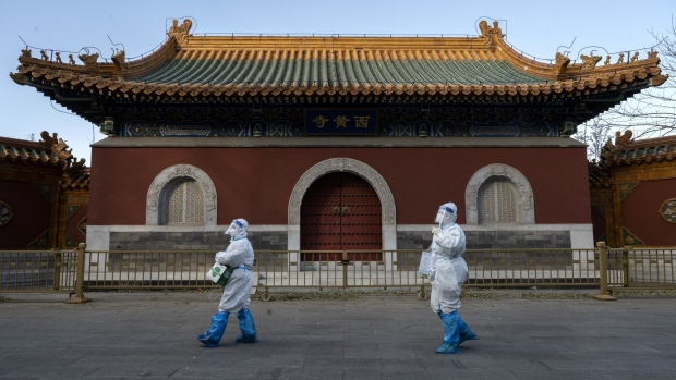 BEIJING, CHINA - DECEMBER 03: Epidemic control workers wear PPE as they walk by the Huangsi Temple on their way to perform nucleic acid tests on people under lockdown or health monitoring for COVID-19 on December 3, 2022 in Beijing, China. (Photo by Kevin Frayer/Getty Images) Photographer: Kevin Frayer/Getty Images AsiaPac