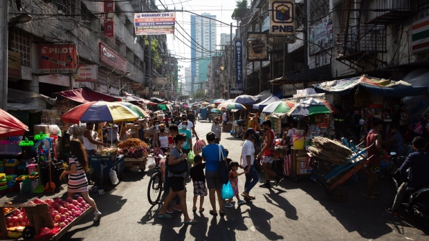 Shoppers walk past stalls at Divisoria Market in Manila, the Philippines, on Sunday, Dec. 5, 2021. The Philippines had loosened virus restrictions in recent weeks as Covid-19 infections declined but with the emergence of the virus variant however, Metro Manila will remain under Alert Level 2 to December 15 and the Southeast Asian nation has rolled back its reopening totourists. Photographer: Geric Cruz/Bloomberg