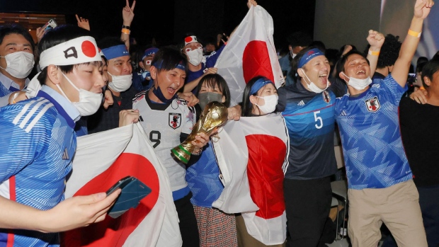 Fans celebrate after Japan's victory over Spain in the Qatar 2022 World Cup Group E football match to advance to the last 16, at a public viewing area in Tokyo on December 2, 2022. Photographer: JIJI Press/AFP/Getty Images