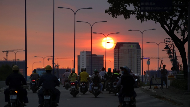 Motorcyclists travel along a road during sunset in Ho Chi Minh City, Vietnam, on Tuesday, Jan. 10, 2017. Vietnam's economy expanded more than 6 percent for a second year in 2016, defying a regional slowdown to remain one of the world's best performers as retails sales rose 10.2 percent. Photographer: Linh Luong Thai/Bloomberg