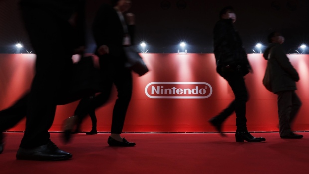 Attendees walks past a sign for Nintendo Co. displayed ahead of an unveiling event for the company's Switch game console in Tokyo, Japan, on Friday, Jan. 13, 2017. Nintendo is counting on the Switch to end years of pain at its console division, which released a successor to the popular Wii in 2012 that flopped. Photographer: Kiyoshi Ota/Bloomberg