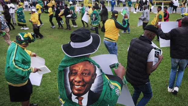 A supporter of Cyril Ramaphosa, South Africa's president, wears a flag bearing his image outside a gathering of African National Congress (ANC) leaders in Johannesburg, South Africa, on Monday, Dec. 5, 2022. Ramaphosa’s lawyers will challenge an advisory panel’s report that said there may be grounds for his impeachment, as the governing party’s top leaders hold a crucial meeting on how to respond to the damning findings.
