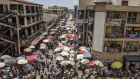 Pedestrians pass by stalls at Makola market in Accra, Ghana, on Thursday, March 15, 2018. Ghana wants to shake up the way it collects tax with the International Monetary Fund telling the government that it’s not raising sufficient income. Photographer: Nicholas Seun Adatsi/Bloomberg