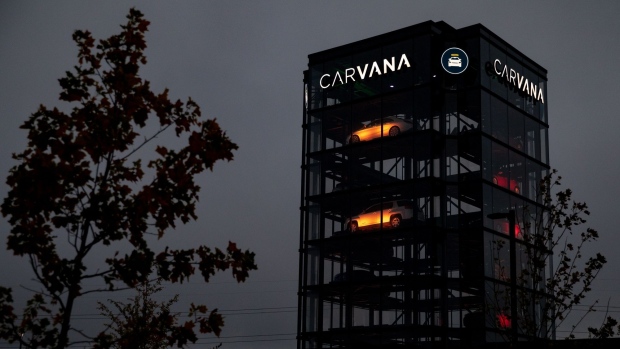 Signage outside a Carvana Vending Machine location in Novi, Michigan, U.S., in Novi, Michigan, U.S., on Sunday, Oct. 31, 2021. Hertz Global Holdings Inc., fresh off a blockbuster order for 100,000 Teslas, reached an exclusive agreement to supply Uber drivers with electric vehicles and signed up Carvana Co. to dispose of rental cars it no longer wants.