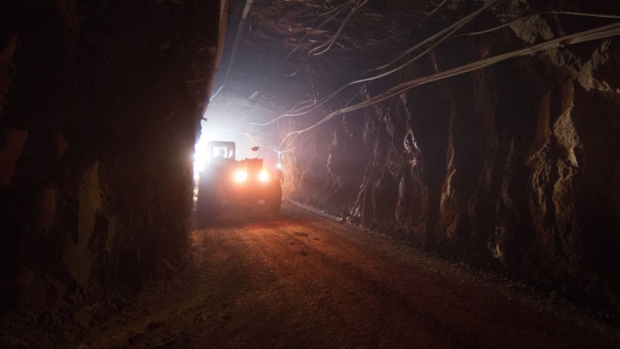 A truck moves through a tunnel to pick up rock ore from the digging floor at the underground gold mine.