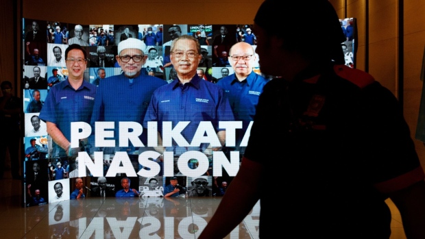 A screen features Muhyiddin Yassin, Malaysia's former prime minister and the leader of Perikatan Nasional party, at an election event in Subang, Malaysia, on Saturday, Nov. 19, 2022. Malaysian voters began casting their ballots Saturday in an election where no one coalition is expected to clinch a parliamentary majority, prolonging instability in a country that has seen three governments in four years. Photographer: Samsul Said/Bloomberg