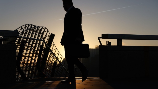 A morning commuter on London Bridge heads towards the City of London, U.K., on Tuesday, Jan. 18, 2022. Britain's labor market grew strongly despite a surge in coronavirus infections late last year, with vacancies hitting a record 1.25 million in the fourth quarter and unemployment falling unexpectedly. Photographer: Hollie Adams/Bloomberg