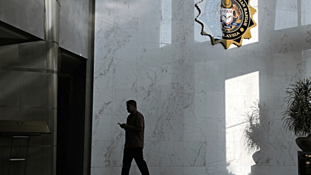 A man walks past the logo of the Malaysian Anti-Corruption Commission at the agency's headquarters ahead of the arrival of former Malaysian Prime Minister Najib Razak in Putrajaya, Malaysia, on Tuesday, May 22, 2018. Najib is at the center of investigations looking into the Malaysian state investment fund known as 1MDB and whether it was used for embezzlement or money laundering.