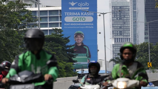 Motorcyclists travel past a billboard advertising GoTo's initial public offering in Jakarta, Indonesia, on Friday, April 8, 2022. GoTo, formed through the merger of Gojek with e-commerce pioneer Tokopedia, raised $1.1 billion in one of the world’s biggest stock debuts this year and is slated to list in Jakarta April 11. Photographer: Dimas Ardian/Bloomberg