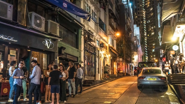 Customers outside a bar at the Lan Kwai Fong nightlife area in Hong Kong. Photographer: Lam Yik/Bloomberg