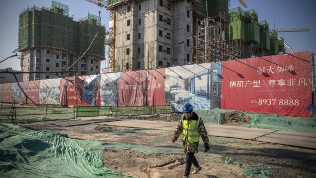 A worker walks past unfinished apartment buildings at the construction site of a China Evergrande Group development in Beijing, China, on Thursday, Jan. 6, 2022. Evergrande is seeking to delay an option for investors to demand early repayment on one of its yuan-denominated bonds, in the latest sign of distress amid a broader real estate debt crisis.