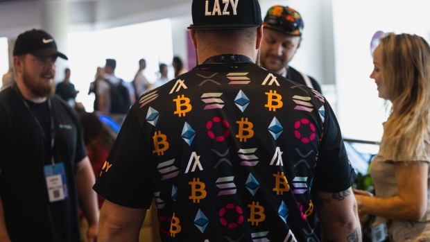 An attendee wears a shirt with cryptocurrency logos during the CoinDesk 2022 Consensus Festival in Austin, Texas, US, on Thursday, June 9, 2022. The festival showcases all sides of the blockchain, crypto, NFT, and Web 3 ecosystems, and their wide-reaching effect on commerce, culture, and communities. Photographer: Jordan Vonderhaar/Bloomberg