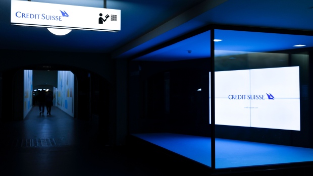 An illuminated sign in the window of a Credit Suisse Group AG bank branch at night in Bern, Switzerland, on Sunday, Nov. 27, 2022. Credit Suisse clients pulled as much as 84 billion Swiss francs ($88.3 billion) of their money from the bank during the first few weeks of the quarter, underlining ongoing concerns over the bank’s restructuring efforts after years of scandals. Photographer: Stefan Wermuth/Bloomberg