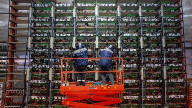 Engineers on a cherry picker adjust mining rigs at the CryptoUniverse cryptocurrency mining farm in Nadvoitsy, Russia, on Thursday, March 18, 2021. The rise of Bitcoin and other cryptocurrencies has prompted the greatest push yet among central banks to develop their own digital currencies. Photographer: Andrey Rudakov/Bloomberg