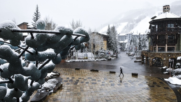 A person walks at the base of a Vail Resorts Inc. location in Vail, Colorado, U.S., on Thursday, March 19, 2020. Colorado Governor Jared Polis ordered the closing of all ski areas, popular resorts located in a region that accounts for 39 of the state's 131 confirmed cases of the new coronavirus, according to official data.