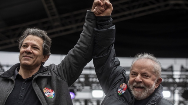 Luiz Inacio Lula da Silva, Brazil's former president, right, and Fernando Haddad, former mayor of Sao Paulo and gubernatorial candidate, raise their hands during a campaign event at Vale do Anhangabau in Sao Paulo, Brazil, on Saturday, Aug. 20, 2022. Datafolha election poll released on Thursday showed incumbent President Jair Bolsonaro narrowing the gap to front-runner Lula to 15 percentage points from 18 points in July and 21 points in May.