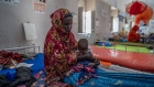 Nimo Hasser, 30, takes care of her severely malnourished child at South Galkayo Hospital in Somalia's Galmudug region on Nov. 21.  Photographer: Simon Marks/Bloomberg