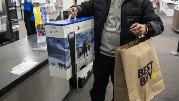 A shopper with a Sony Playstation 5 at a Best Buy store on Black Friday in San Francisco, California, US, on Friday, Nov. 25, 2022. US retailers are bracing for a slower-than-normal Black Friday as high inflation and sagging consumer sentiment erode Americans’ demand for material goods.