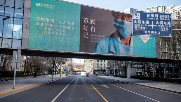 A message about epidemic prevention on a screen over a near empty road in Beijing, China, on Tuesday, Dec. 13. 2022. China's abrupt ending of its Covid Zero policy injects more uncertainty into an already fragile economy, raising the prospect of looser fiscal and monetary policy and more easing in the property market to bolster growth.