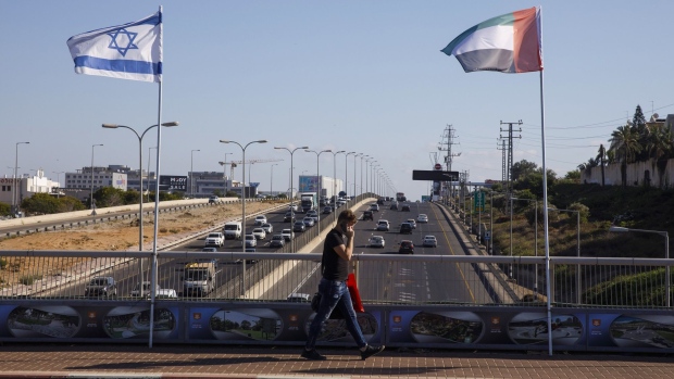 A pedestrian walks by an Israeli national flag flying alongside a United Arab Emirates national flag on the side of a road in Netanya, Israel, on Monday, Aug. 17, 2020. Israel and the United Arab Emirates reached an agreement to begin normalizing relations, a potentially historic breakthrough hailed by American and Israeli leaders as a crucial step toward peace yet assailed by Palestinian officials as a betrayal. Photographer: Kobi Wolf/Bloomberg