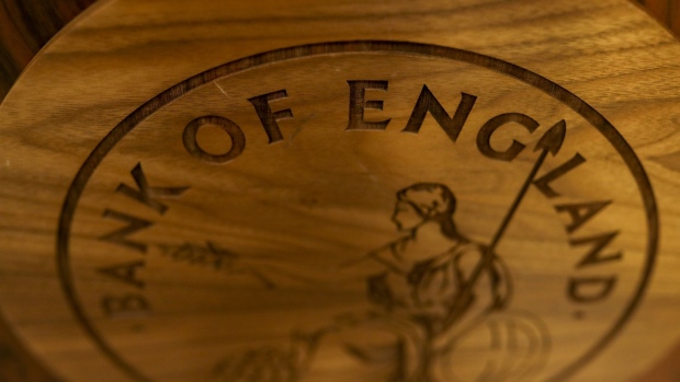 A wooden plaque of the Bank of England (BOE) logo sits on a desk ahead of the bank's quarterly inflation report news conference in the City of London, U.K., on Thursday, Aug. 1, 2019. BOE Governor Mark Carney will confront the new realities of Brexit and the increasing likelihood of a no-deal departure from the European Union in the central bank’s interest-rate decision on Thursday. Photographer: Simon Dawson/Bloomberg