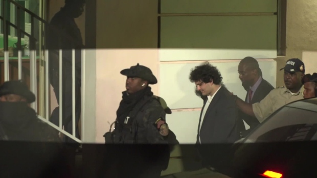 (EDITORS NOTE: Best quality available) Sam Bankman-Fried, founder of FTX, center right, is escorted out of the Magistrate's Court in Nassau, Bahamas, on Tuesday, Dec. 13, 2022. Bankman-Fried was denied bail by a judge, leaving the disgraced co-founder of crypto giant FTX behind bars.
