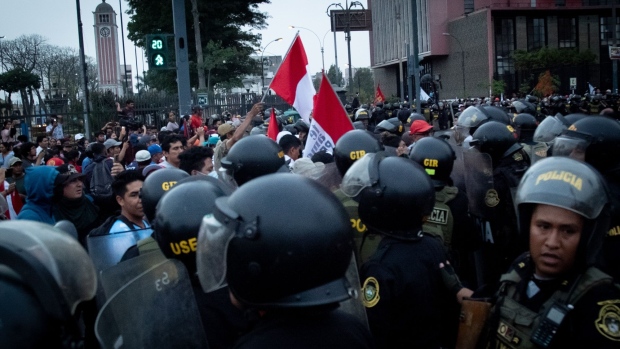 Riot police officers clash with demonstrators during protests on Avenida de Pierola in Lima, Peru, on Thursday, Dec. 15, 2022. Peru has declared a nationwide state of emergency, suspending basic rights for 30 days, to try to restore order amid widespread violent unrest.