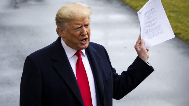 U.S. President Donald Trump holds a copy of a U.S. appeals court ruling as he speaks to members of the media before boarding Marine One on the South Lawn of the White House in Washington, D.C., U.S., on Friday, Feb. 7, 2020. Trump mostly stifled his fury toward the impeachment witnesses who detailed, over hundreds of hours of testimony, the turmoil wrought by his handling of Ukraine policy. Now that he's been acquitted of two impeachment charges, they're bracing for payback.