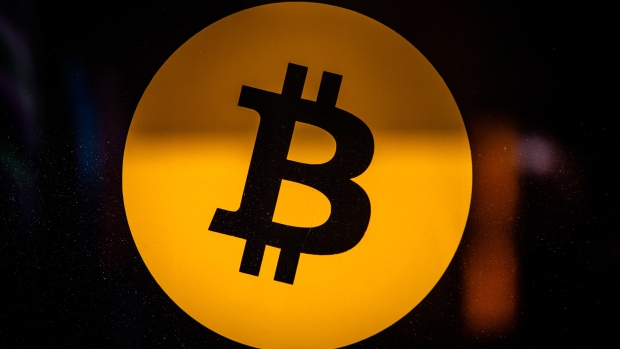 A Bitcoin logo in the window of a BitBase cryptocurrency exchange in Barcelona, Spain, on Monday, May 16, 2022. The wipeout of algorithmic stablecoin TerraUSD and its sister token Luna knocked more than $270 billion off the crypto sector’s total trillion-dollar value in the most volatile week for Bitcoin trading in at least two years. Photographer: Angel Garcia/Bloomberg