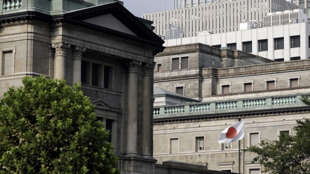 A Japanese national flag flies outside the Bank of Japan (BOJ) headquarters in Tokyo, Japan, on Monday, Sept. 14, 2020. The Bank of Japan left its bond-purchase amount unchanged at a regular operation on Monday.