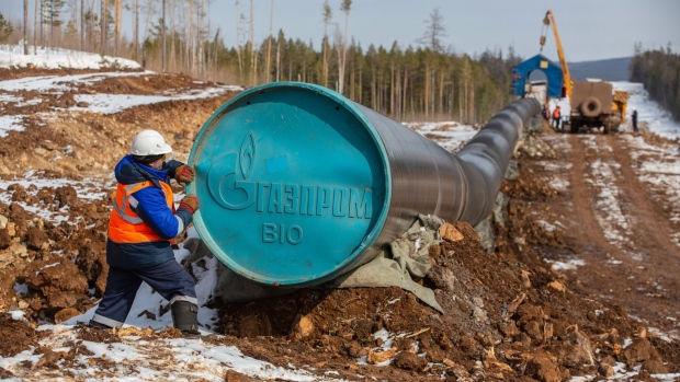 A worker adjusts a Gazprom branded end cap on a section of pipework during pipeline laying operations for the Gazprom PJSC Power of Siberia gas transmission line between the Kovyktinskoye and Chayandinskoye gas fields near Irkutsk, Russia, on Tuesday, April 6, 2021. Built by Russian energy giant Gazprom, the pipeline runs about 3,000 kilometers (1,864 miles) from the Chayandinskoye and Kovyktinskoye gas fields in the coldest part of Siberia to Blagoveshchensk, near the Chinese border.