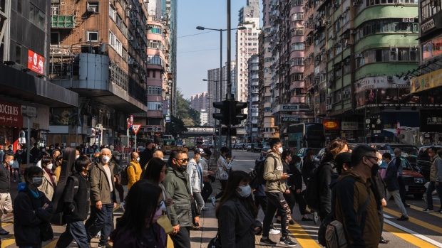 Pedestrians cross a street in Mong Kok district in Hong Kong, China, on Thursday, Dec. 29, 2022. Hong Kong will end some of its last major Covid rules, scrapping gathering limits to vaccination checks and testing for travelers, in a sweeping overhaul of policies aimed at reviving its reputation as a global financial center.