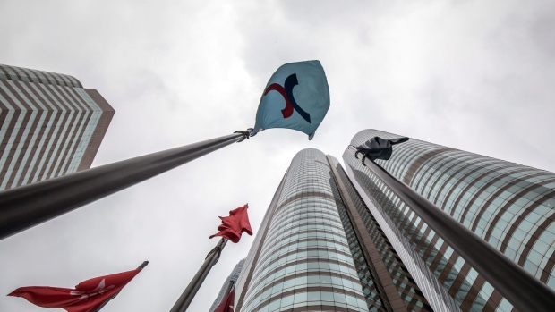 A Hong Kong Exchanges and Clearing Ltd. (HKEx) flag, center, in Hong Kong, China, on Friday, Dec. 16, 2022. A pair of Hong Kong exchange-traded funds investing in Bitcoin and Ether futures raised $79 million as the city pushes ahead with a plan to become a crypto hub even as the sector globally reels from the FTX collapse. Photographer: Paul Yeung/Bloomberg