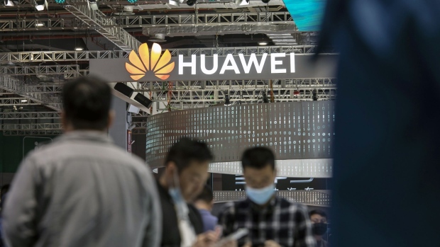 Visitors walk past a logo at the Huawei Technologies Co. booth at the Auto Shanghai 2021 show in Shanghai, China, on Tuesday, April 27, 2021. The Shanghai International Automobile Industry Exhibition kicked off on April 19 in China's financial hub, a multiday event aimed at showcasing the best and brightest car innovations in the worlds biggest vehicle market. Photographer: Qilai Shen/Bloomberg