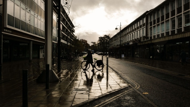 A cyclist pushes their bike along The Broadway in Crawley, UK, on Wednesday, Nov. 16, 2022. UK inflation rose more than expected to a 41-year high of 11.1%, adding to pressure on the Bank of England to raise interest rates again. Photographer: Jose Sarmento Matos/Bloomberg
